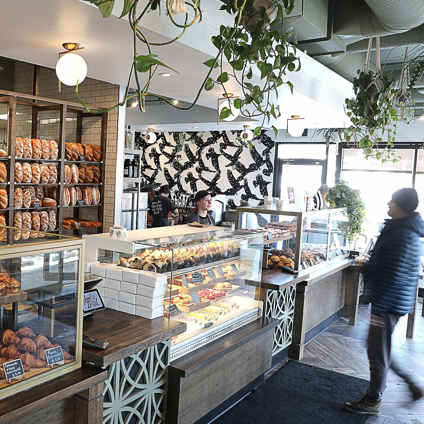 A man is standing in front of a bakery counter.
