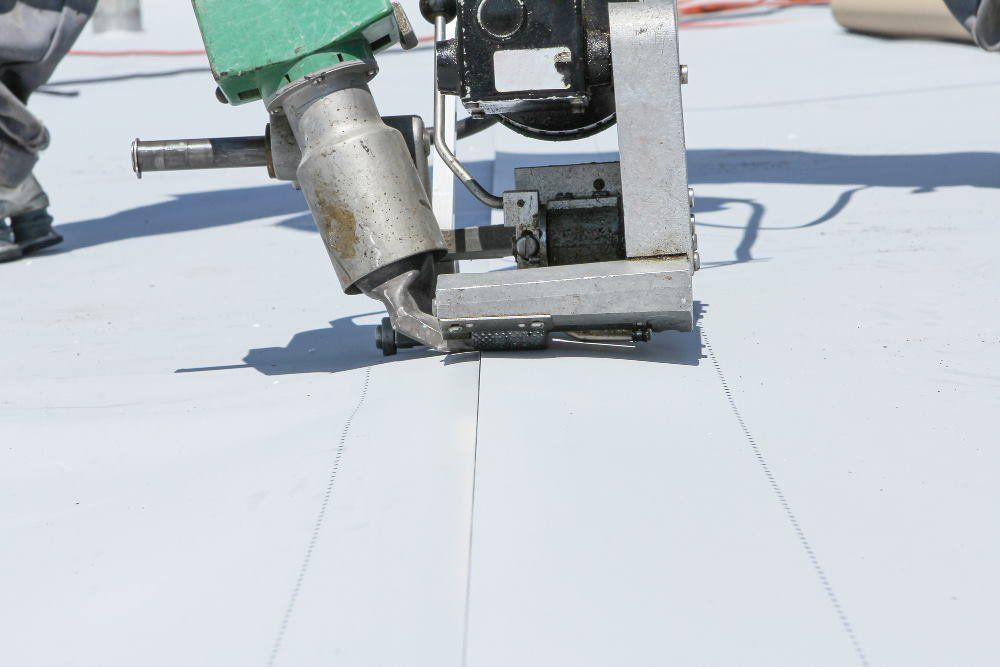 Photo showing a machine pinching the seams of a PVC roof during a Roof repair process in Mobile