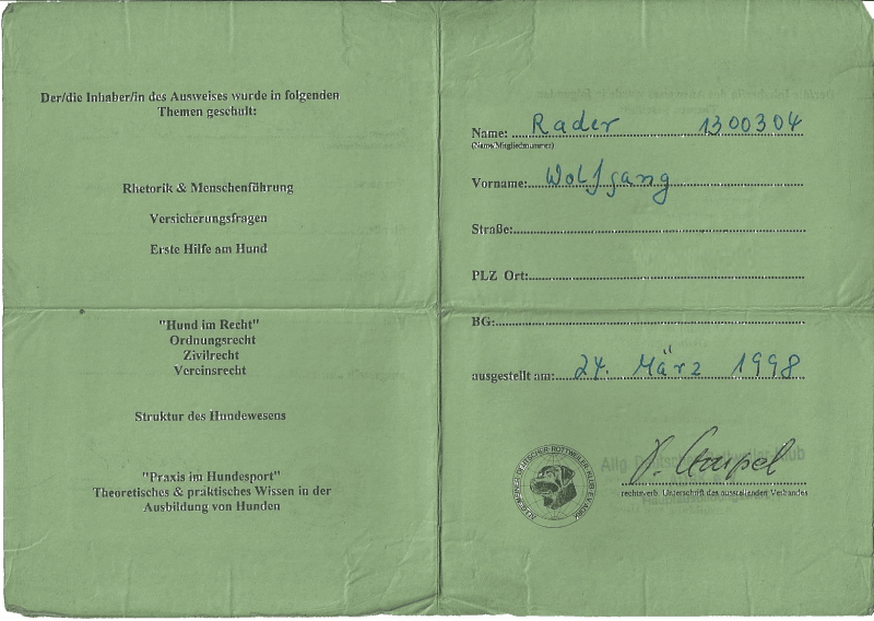 Green folded document with handwritten Arabic text and official stamps/signatures on both pages