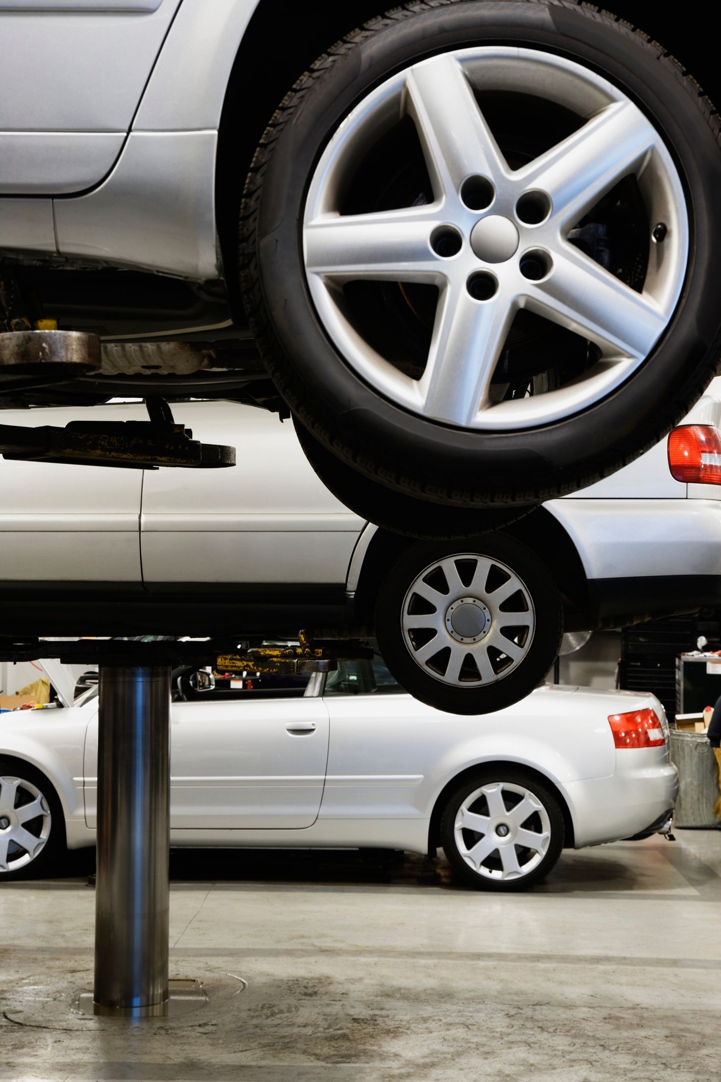 A silver car is sitting on a lift in a garage