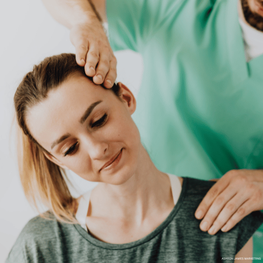 Chiropractor adjusting a woman's neck in a medical setting.