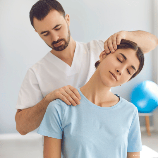 Chiropractor adjusting a woman's neck in a clinic. She has her eyes closed while he uses his hands on her head and shoulder.