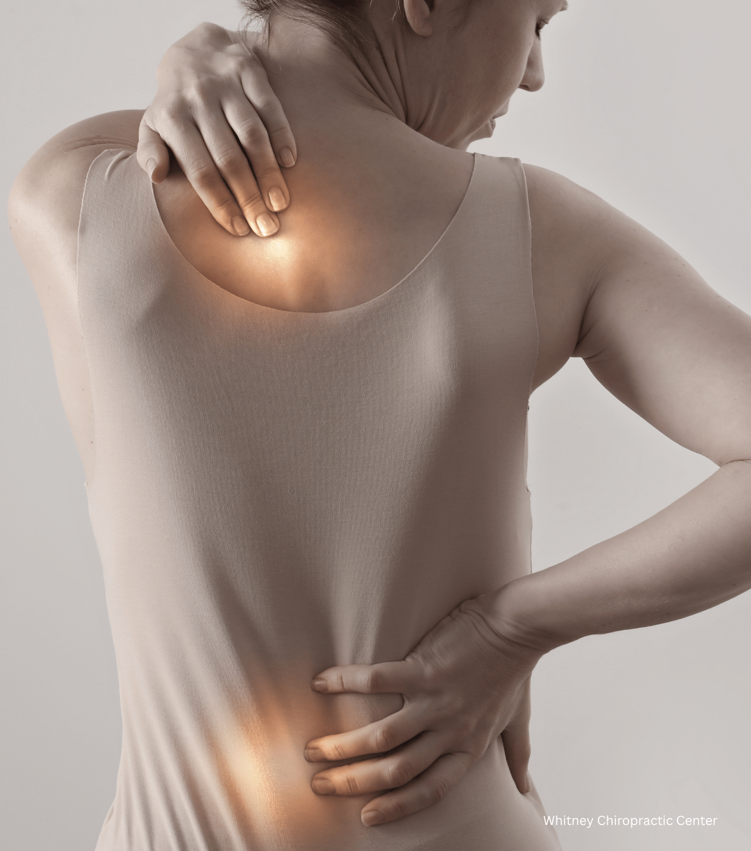 A woman is holding her shoulder and back in pain
