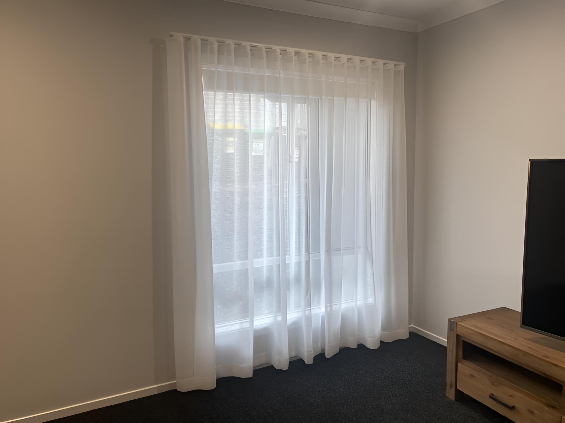 A Living Room With a Sliding Glass Door and White Curtains — Lismore Curtains & Blinds In Ballina, NSW