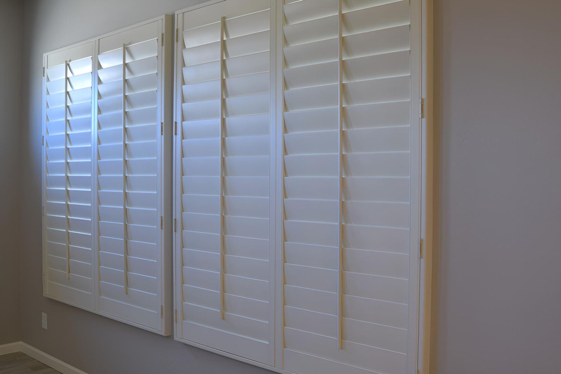 Three White Shutters Are Hanging on a Wall in a Room — Lismore Curtains & Blinds In Ballina, NSW