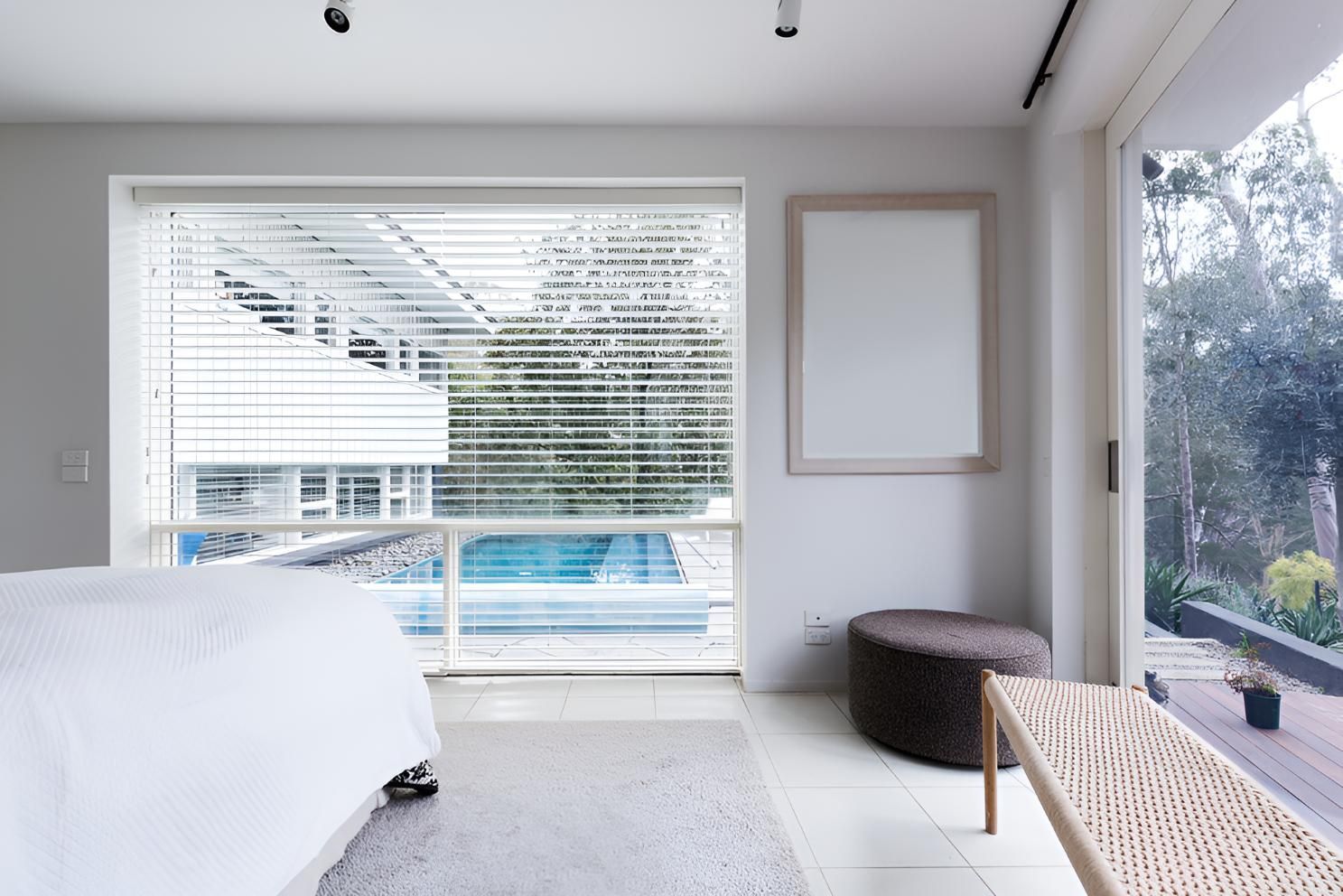 A Bedroom With a Window With Blinds And a Pool Outside — Lismore Curtains & Blinds In Ballina, NSW
