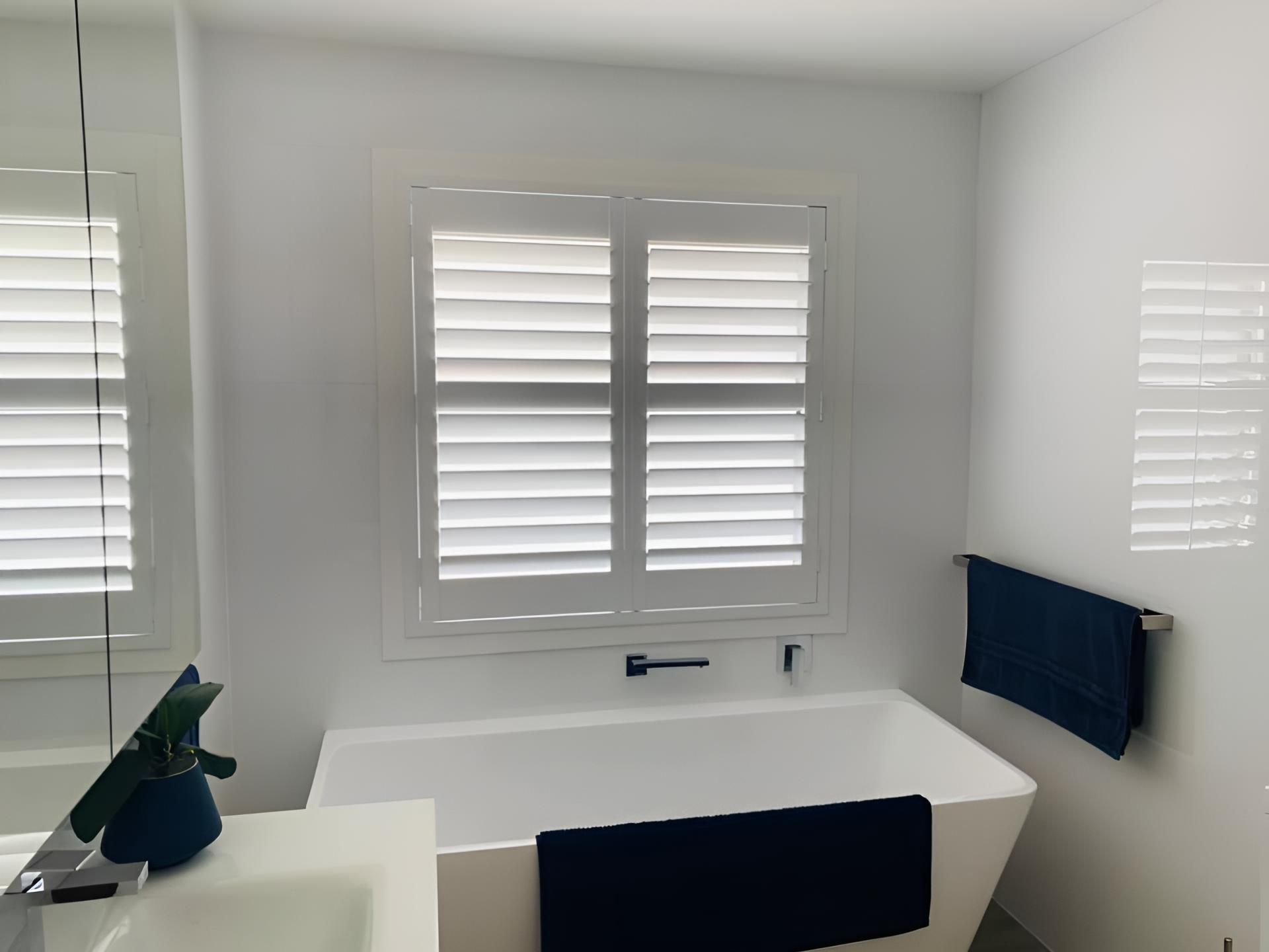 A Bathroom With a Bathtub, Sink, Mirror and Window — Lismore Curtains & Blinds In Byron Bay, NSW