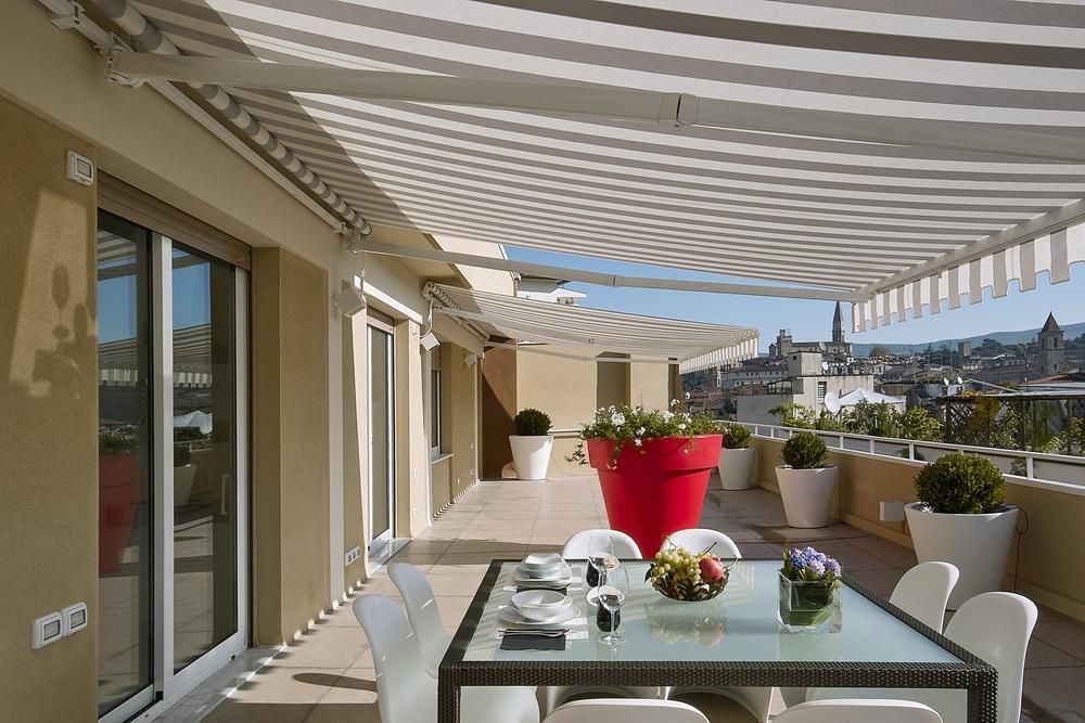 A Patio With a Table and Chairs Under an Awning — Lismore Curtains & Blinds In Casino, NSW