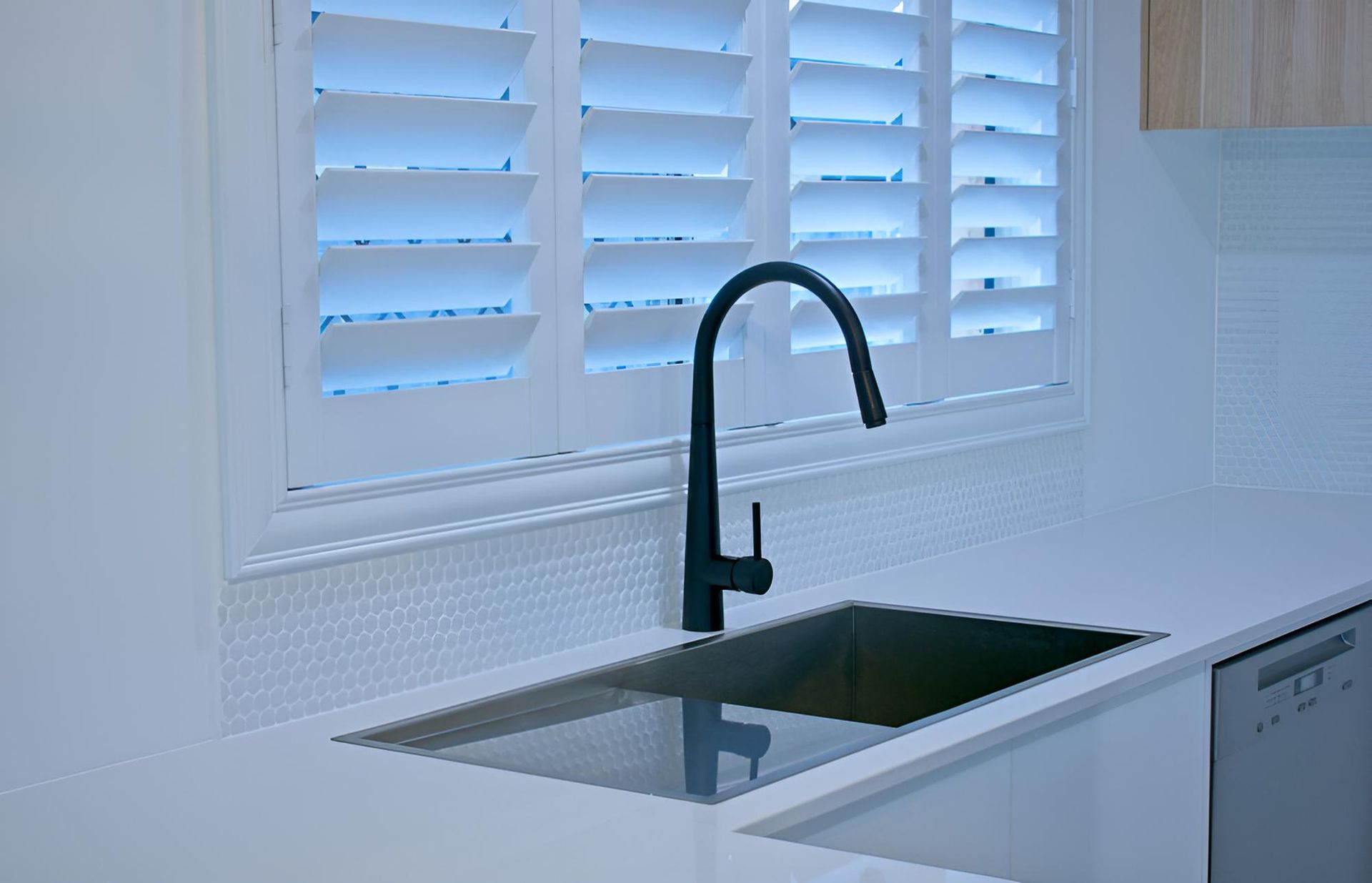 A Kitchen Sink With a Black Faucet and Shutters on the Window — Lismore Curtains & Blinds In Casino, NSW