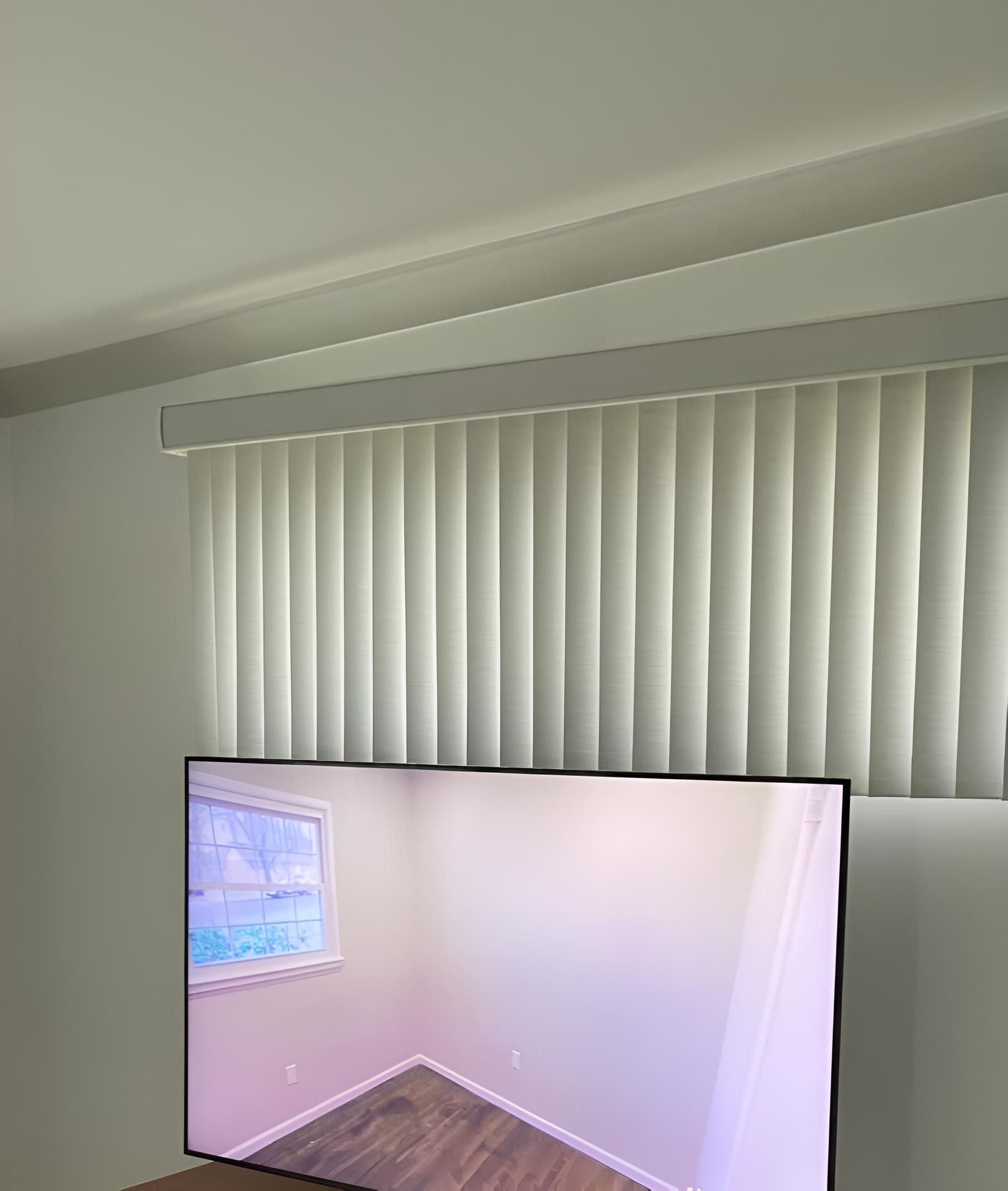 A Flat Screen Tv is Sitting in a Living Room Next to a Window — Lismore Curtains & Blinds In Lismore, NSW