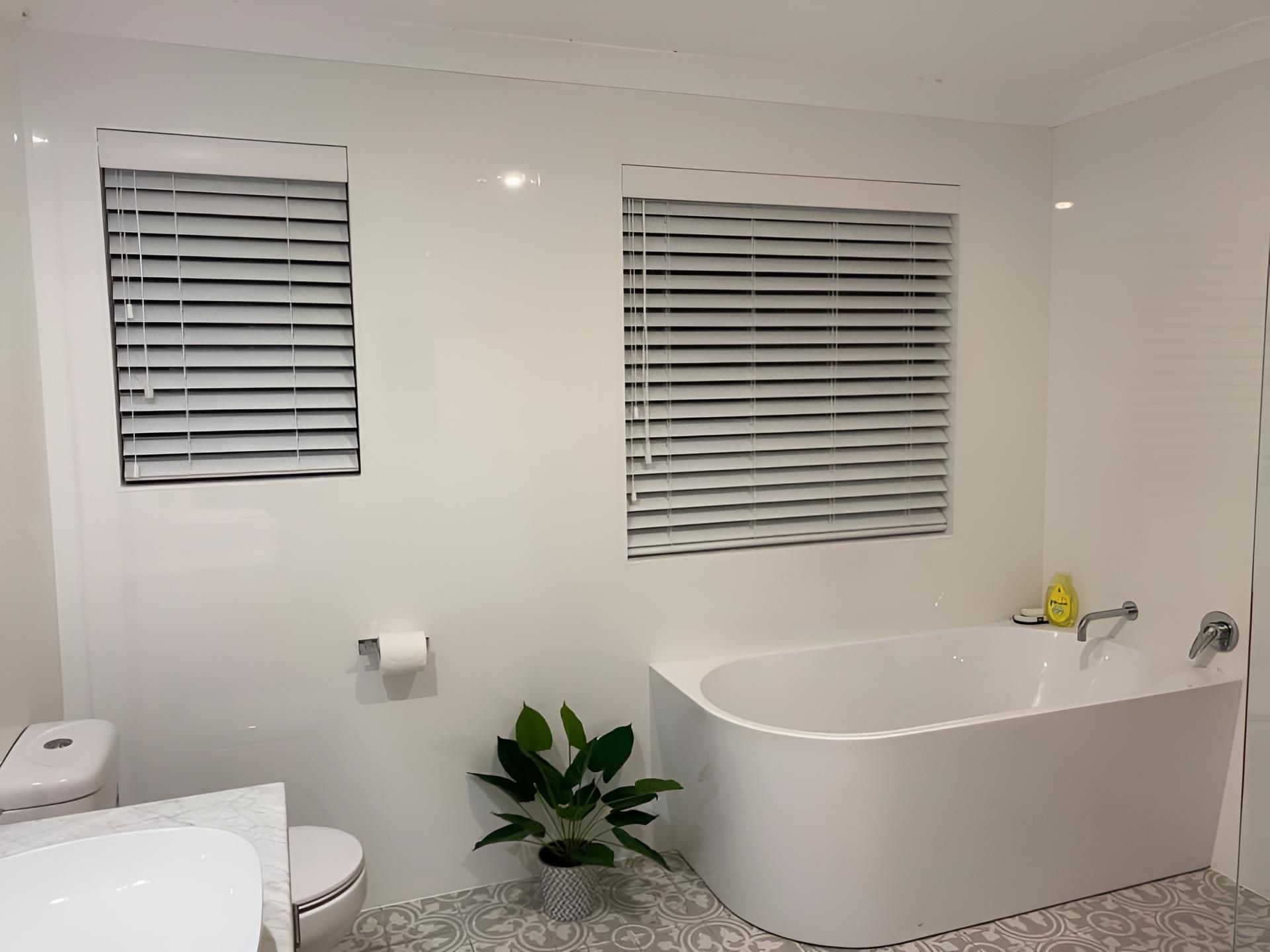 A Bathroom With a Tub , Toilet , Sink and Two Windows — Lismore Curtains & Blinds In Lismore, NSW