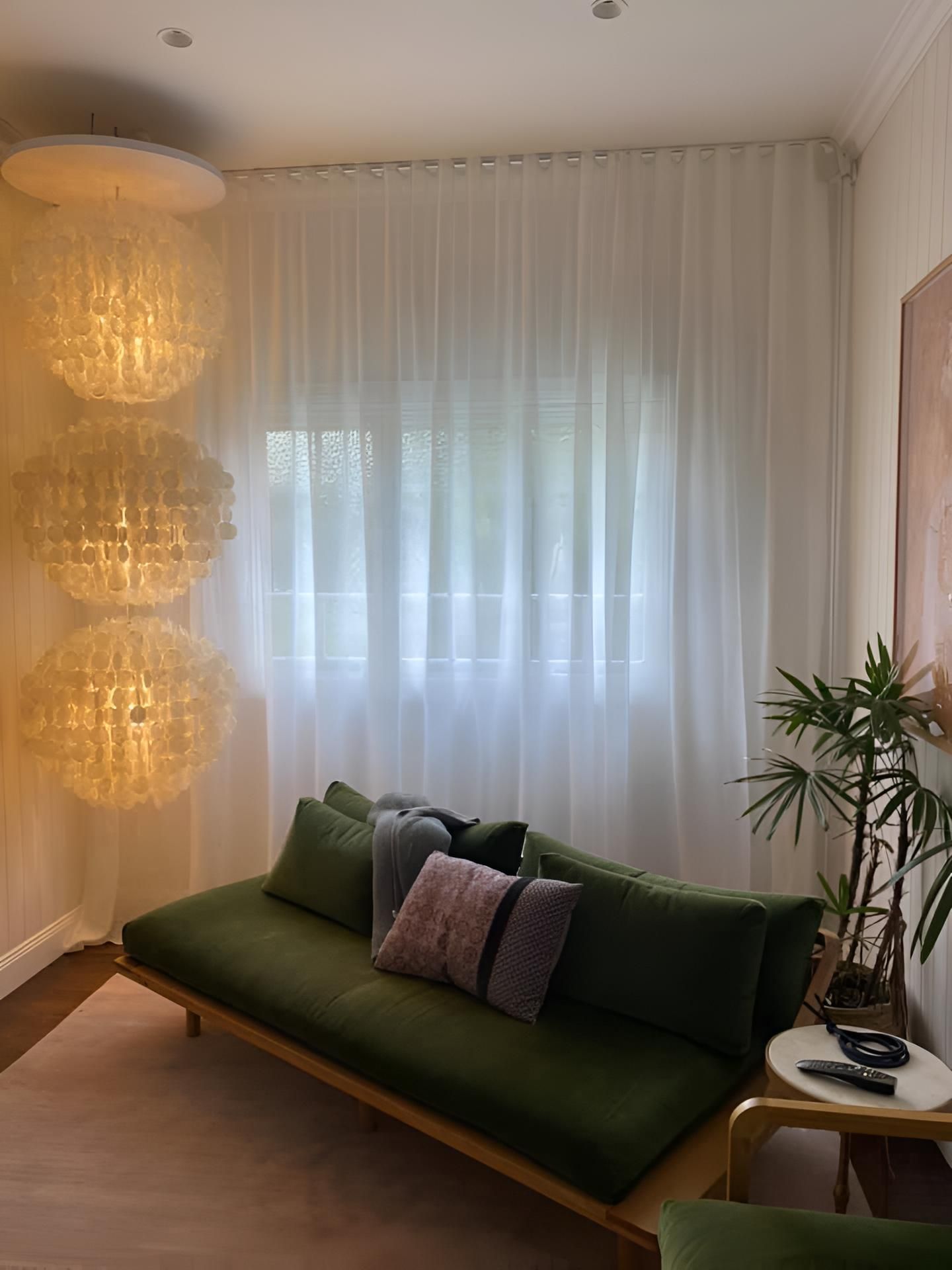 A Living Room With a Green Couch and White Curtains — Lismore Curtains & Blinds In Lismore, NSW