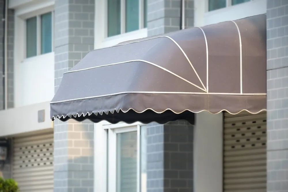 A Gray Awning is on the Side of a Building — Lismore Curtains & Blinds In Lismore, NSW