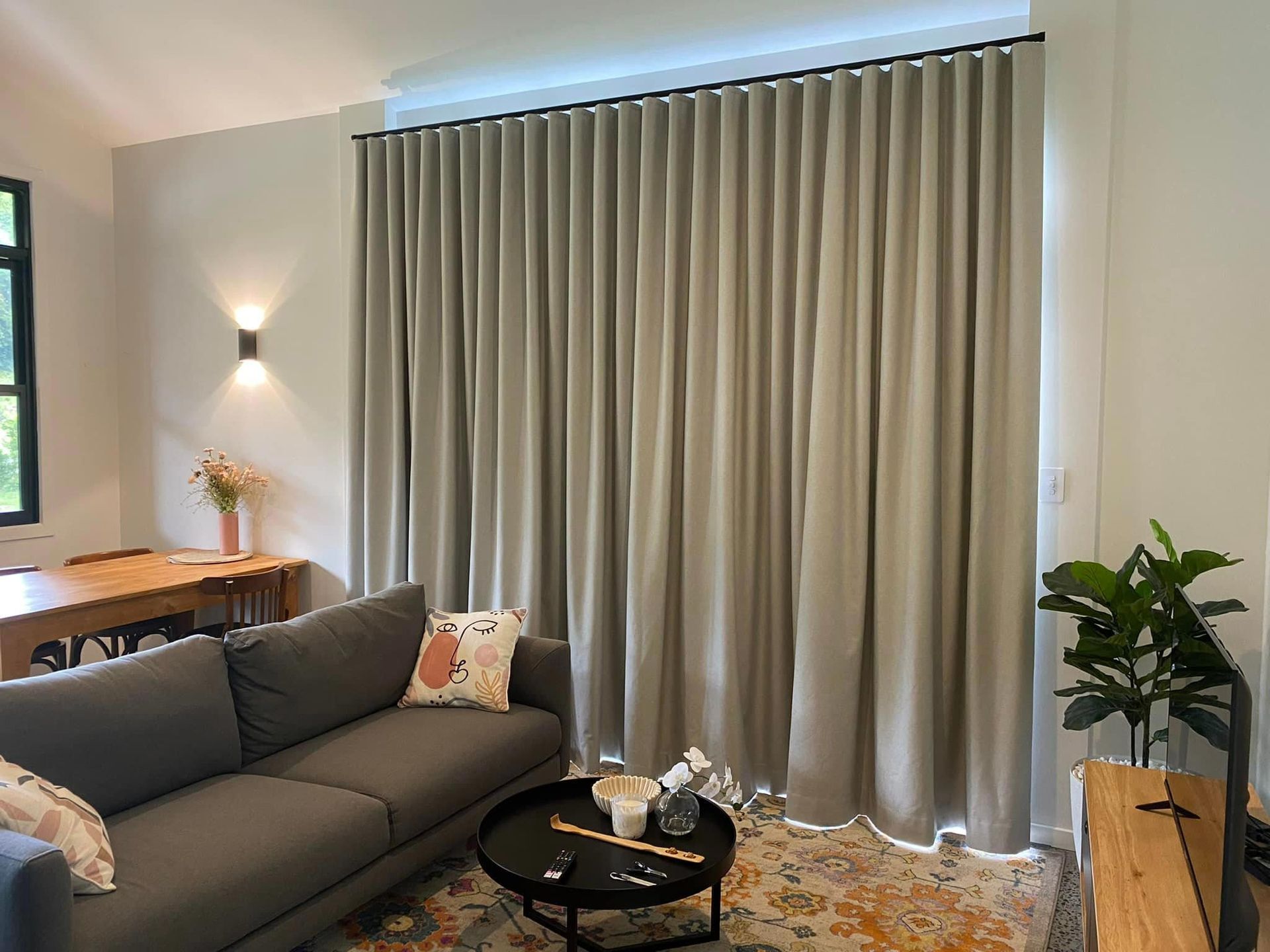 A living room with long grey curtains closed over the window.