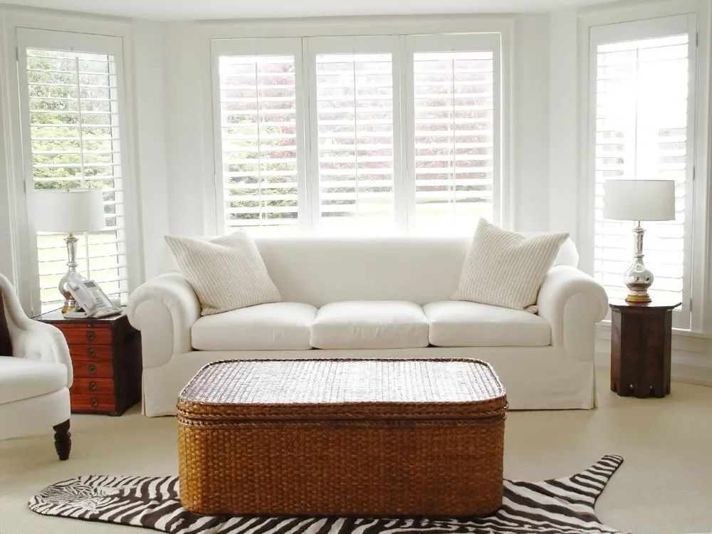 A Living Room With a White Couch and a Wicker Coffee Table — Lismore Curtains & Blinds In Lismore, NSW