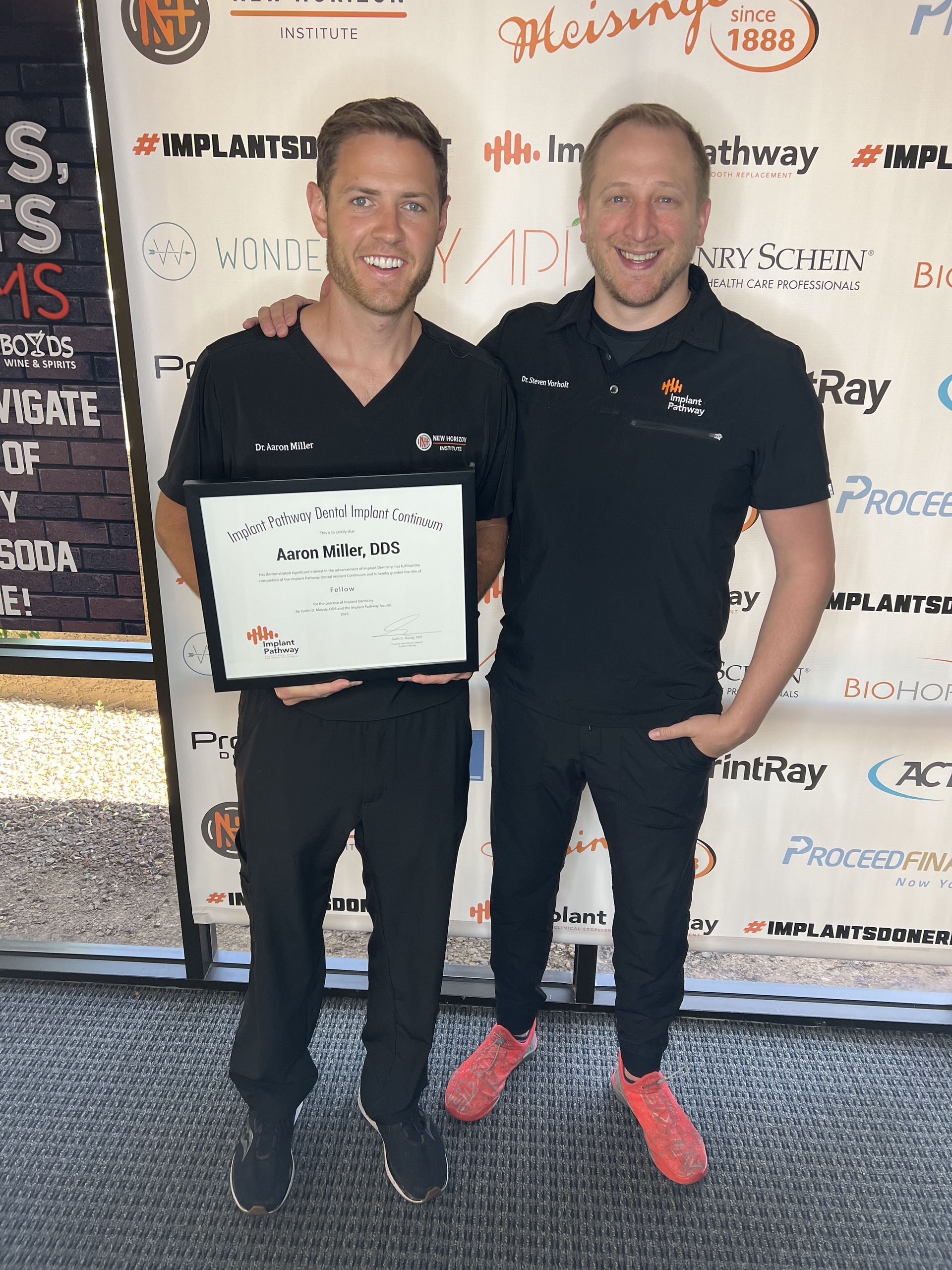 Steven Vorholt smiling with Aaron Miller who is holding his Implant Pathway completed course diploma.