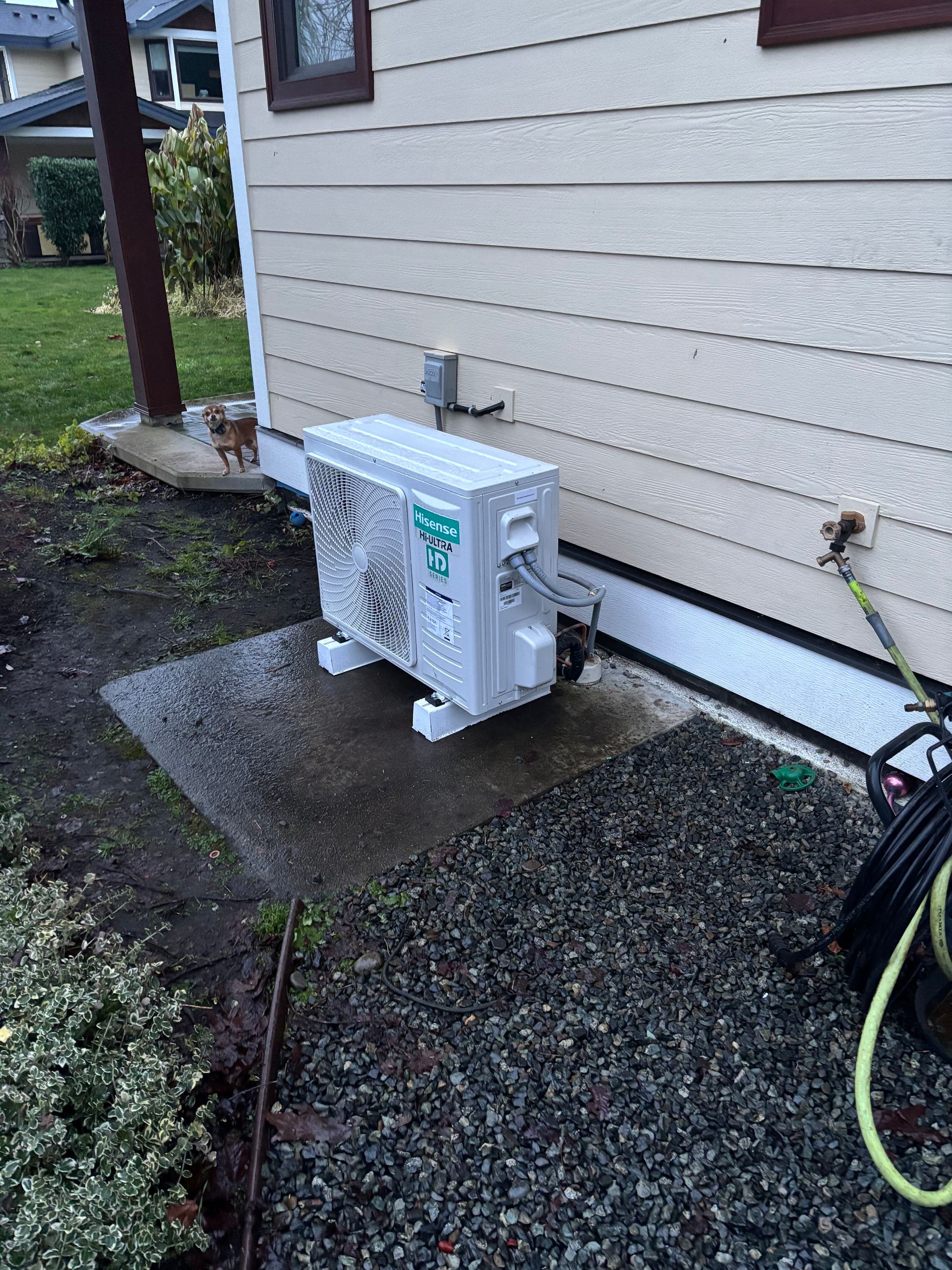 A new working heat pump is sitting on the side of a house.