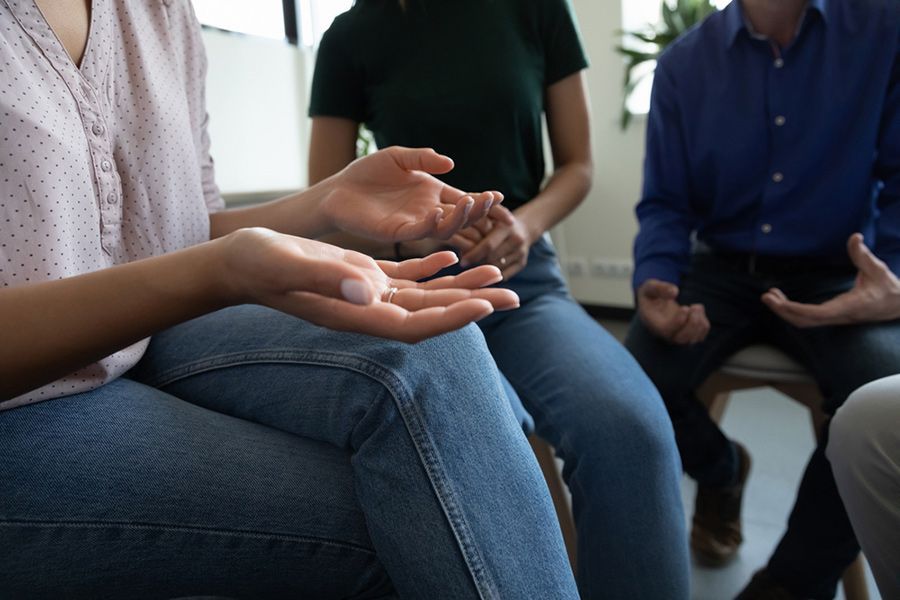 People in a Circle, Some Gesturing With Hands; a Meeting or Therapy Session — Thrive Therapy Solutions in Cairns, QLD