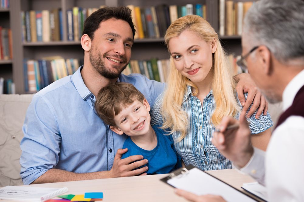 A Family is Sitting at a Table Talking to a Doctor — Thrive Therapy Solutions in Scarborough, WA