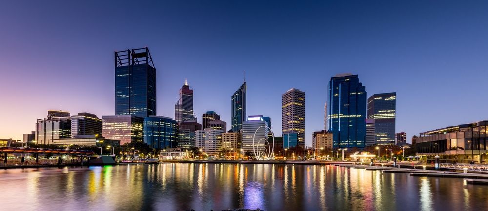 A City Skyline Overlooking a Body of Water at Night — Thrive Therapy Solutions in Doubleview, WA