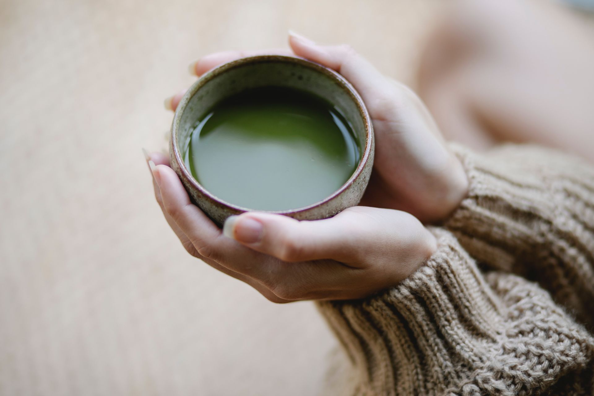 Hands holding a Ceramic Bowl of Green Matcha Tea — Thrive Therapy Solutions in Cairns City, QLD