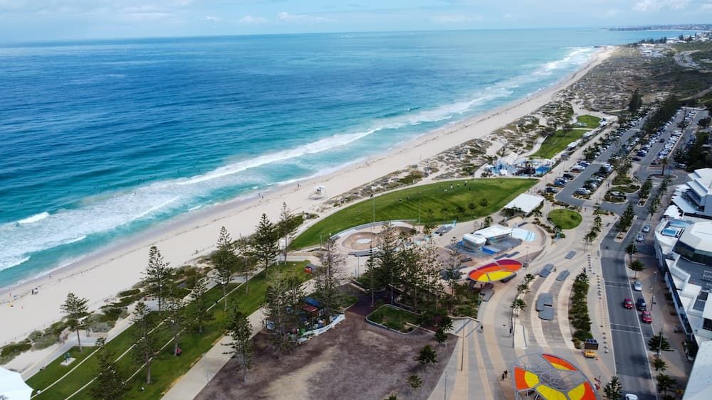 A Beach With a Park in the Foreground and the Ocean in the Background — Thrive Therapy Solutions in Scarborough, WA