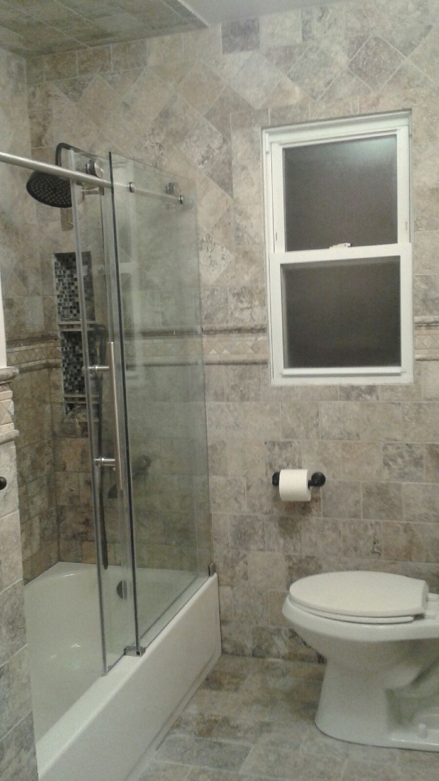 Bathroom with tiled walls, shower, bathtub, toilet, and window.