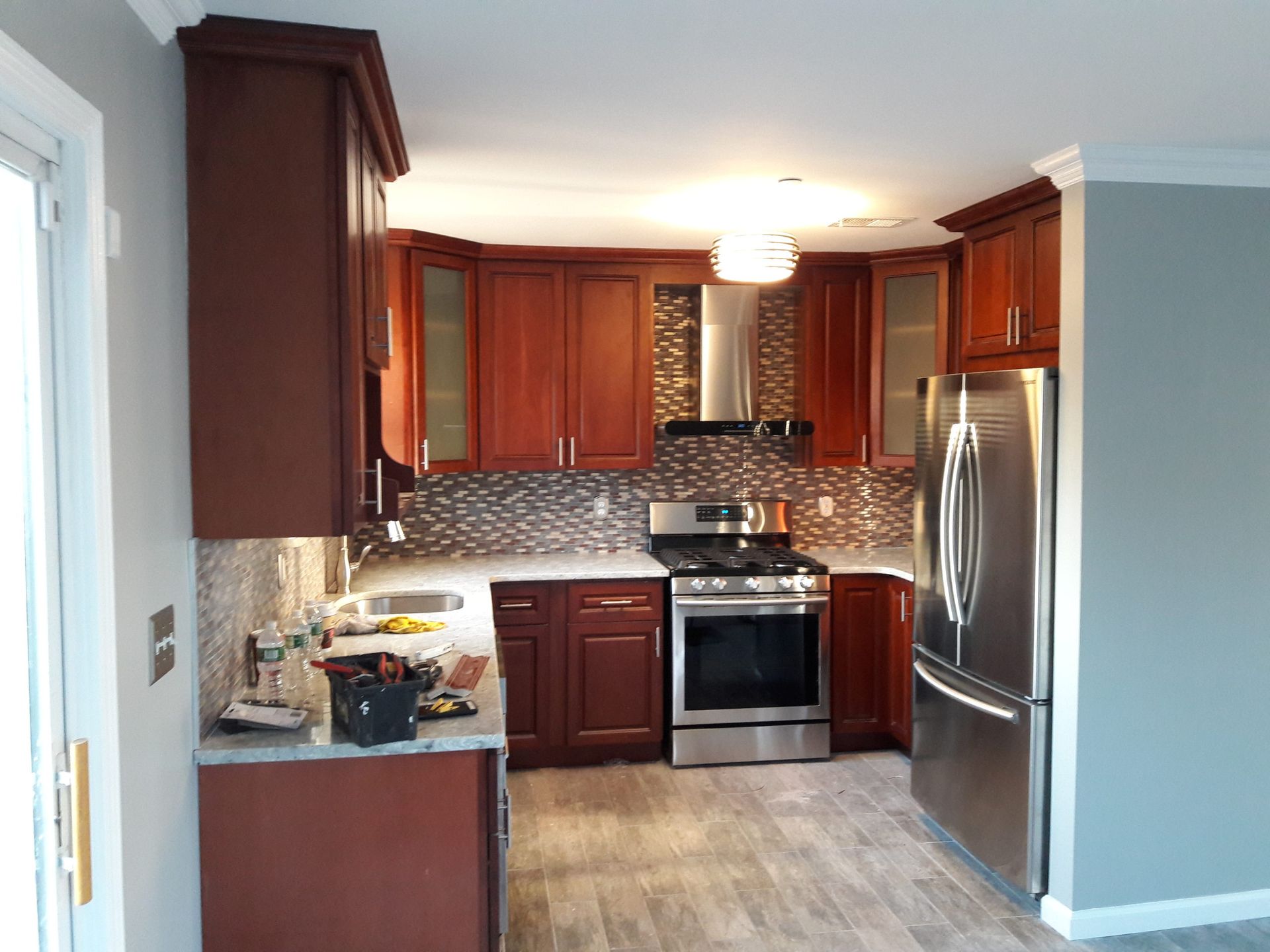 Newly renovated kitchen with dark wood cabinets, stainless steel appliances, and tile backsplash.