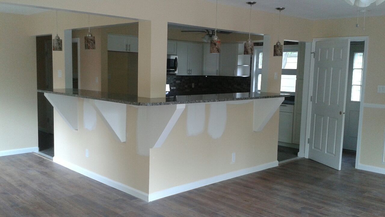 Kitchen with a breakfast bar, featuring a granite countertop and beige walls.