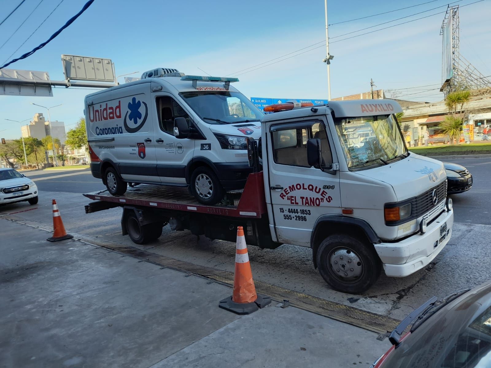 Una ambulancia está siendo remolcada por una grúa.