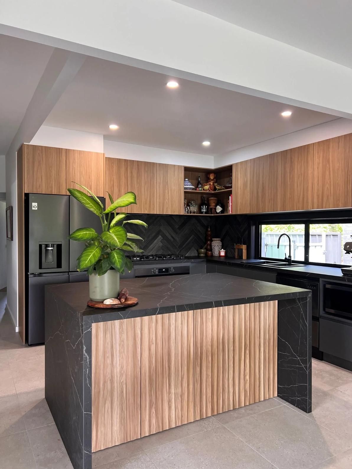 A Kitchen With a Large Island and a Plant on the Counter — The Kitchen Centre In Tuggerah, NSW