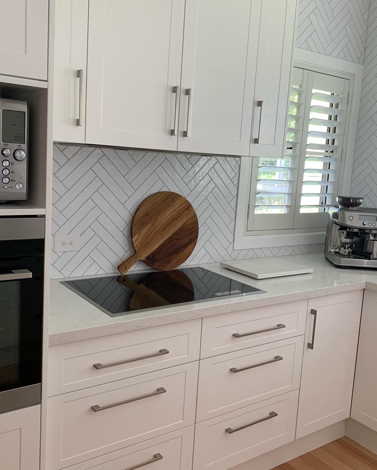 A Kitchen With White Cabinets and a Wooden Cutting Board on the Counter — The Kitchen Centre In Wyong, NSW