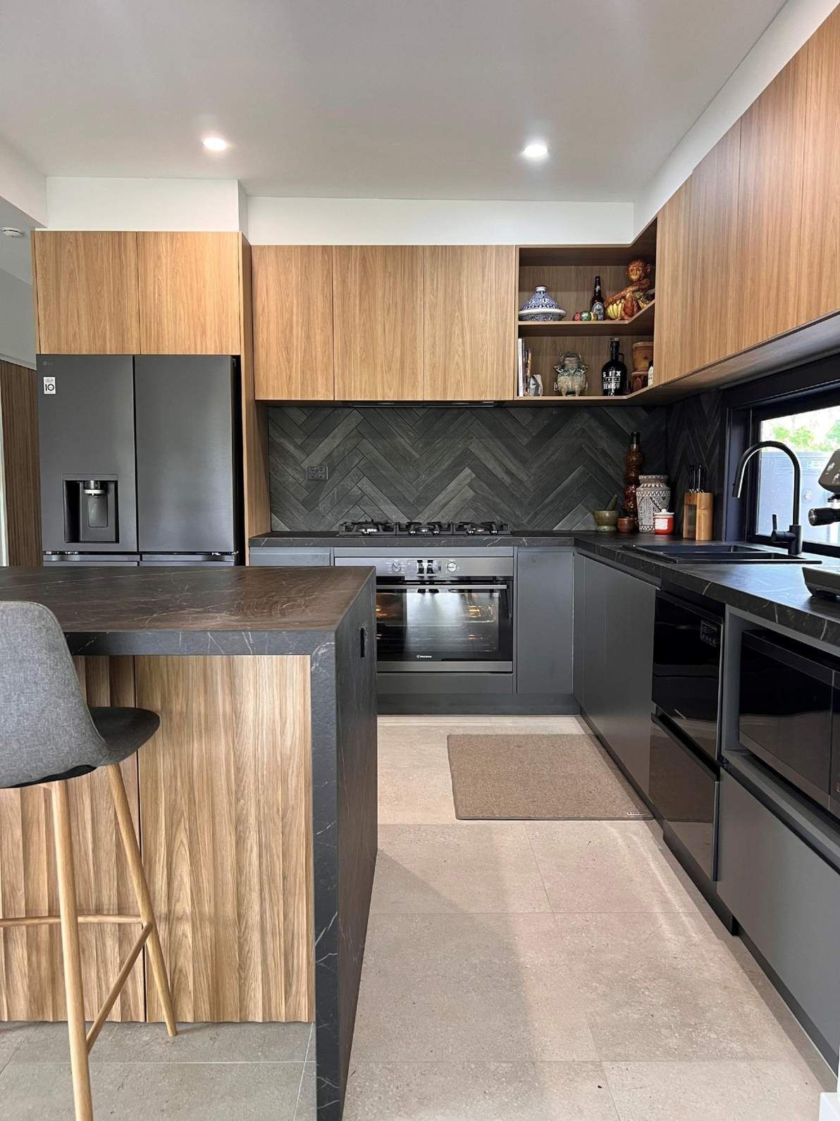 A Kitchen With Wooden Cabinets, a Black Refrigerator, a Stove, and a Sink — The Kitchen Centre In Tuggerah, NSW
