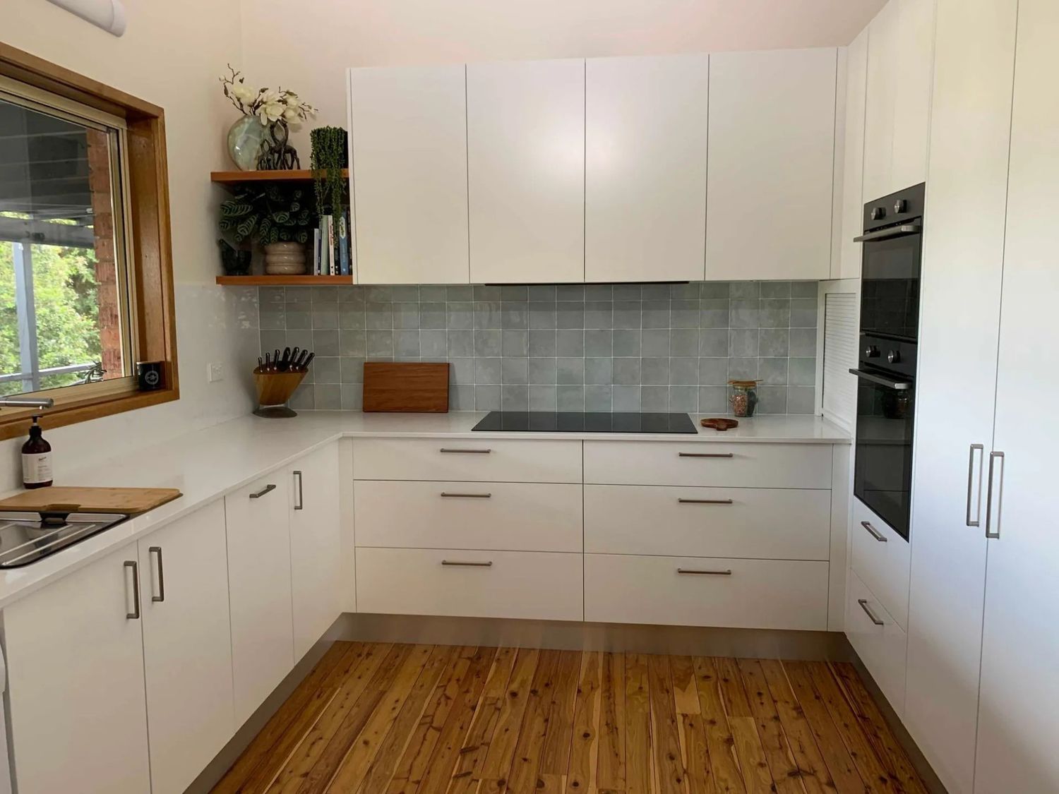 A Kitchen With White Cabinets and Wooden Floors — The Kitchen Centre In Tuggerah, NSW