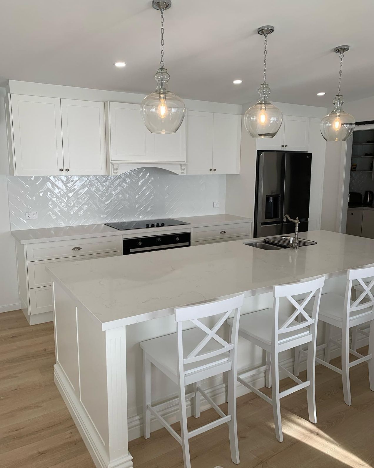 A Kitchen With White Cabinets, a Large Island, Stools and a Refrigerator — The Kitchen Centre In The Entrance, NSW