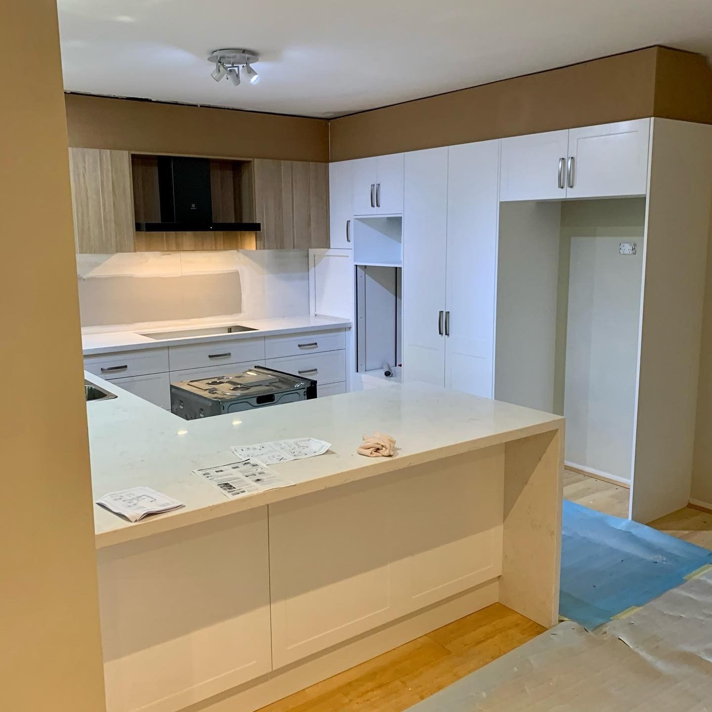 A Kitchen With White Cabinets and Wooden Floors is Being Remodelled — The Kitchen Centre In Tuggerah, NSW