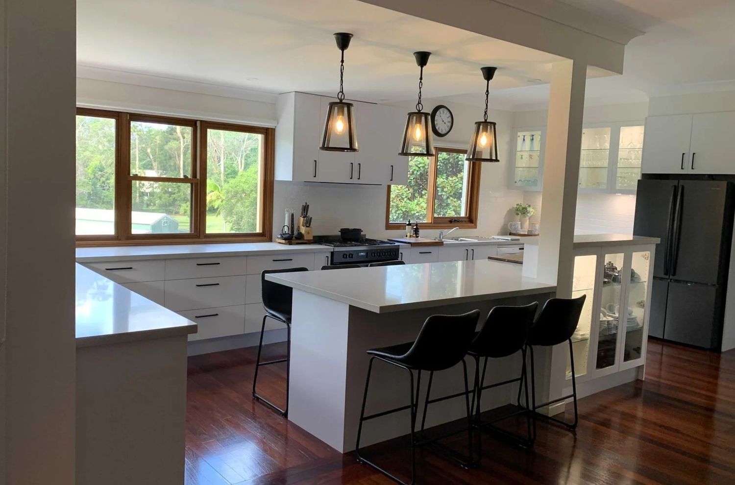 A Kitchen With White Cabinets Stools and a Refrigerator — The Kitchen Centre In Tuggerah, NSW