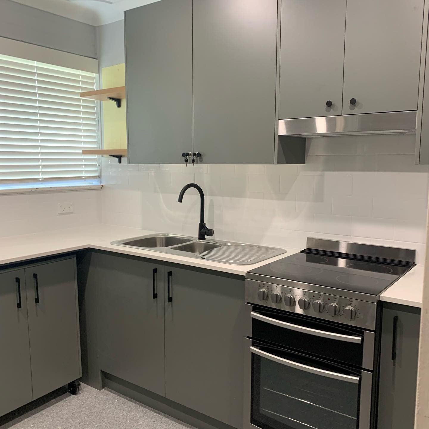 A Kitchen With Gray Cabinets, a Stove, a Sink, and a Window — The Kitchen Centre In Wyong, NSW