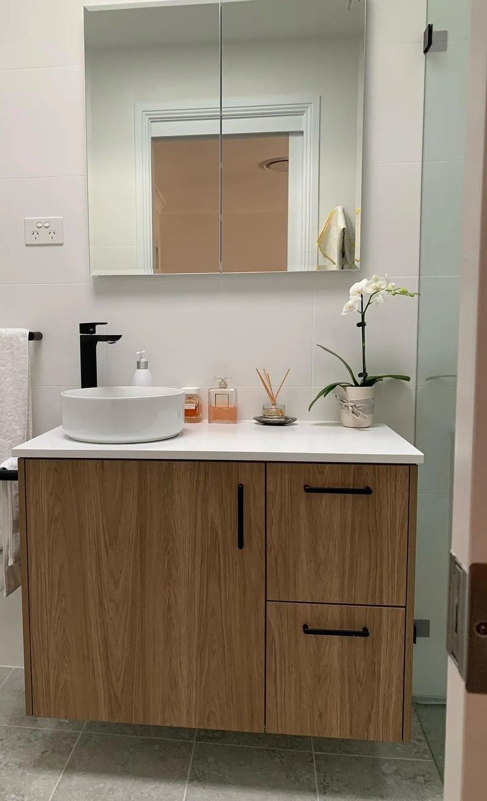 A Bathroom With a Sink, Mirror and Towels — The Kitchen Centre In Tuggerah, NSW