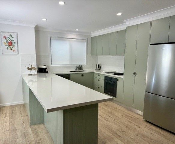 Green Kitchen With White Countertops, A Steel Fridge, And Wooden Floors — The Kitchen Centre In Tuggerah, NSW