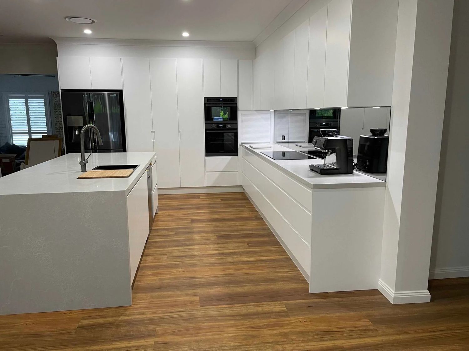 A Kitchen With White Cabinets and Wooden Floors — The Kitchen Centre In Tuggerah, NSW