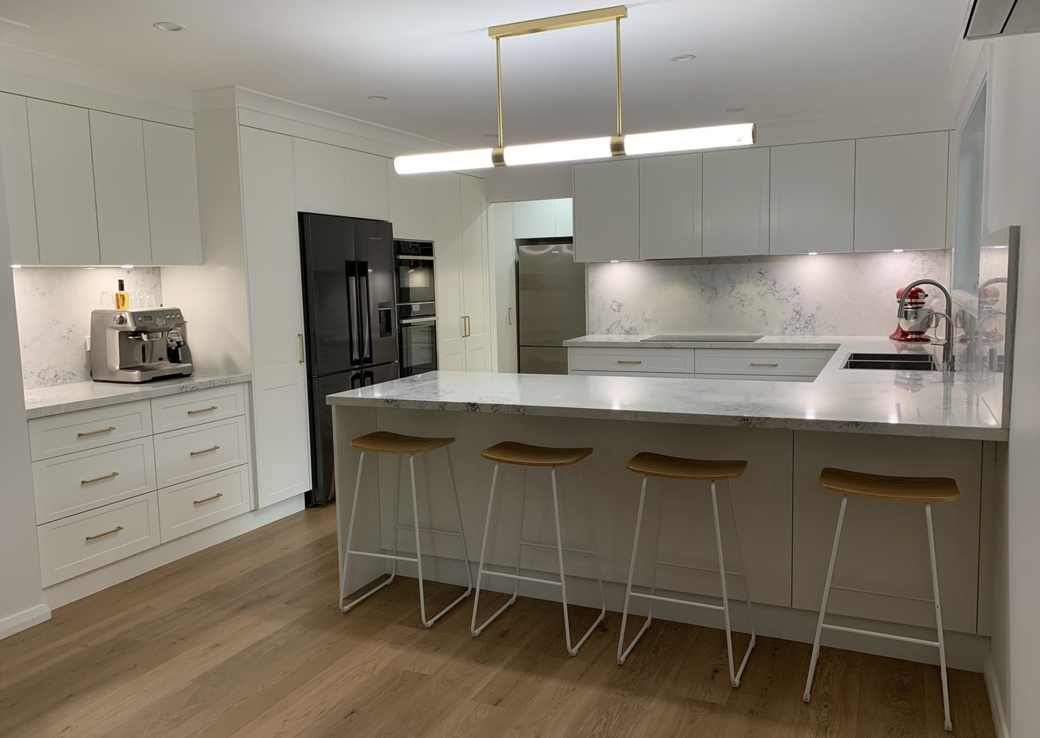 A Kitchen With White Cabinets and Stools and a Large Island — The Kitchen Centre In Tuggerah, NSW
