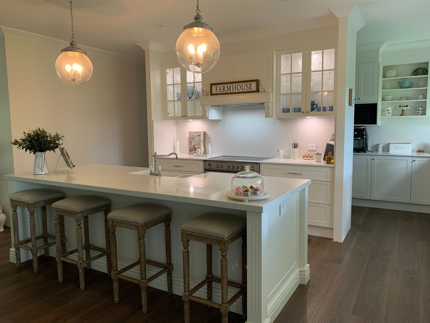 A Kitchen With White Cabinets and Stools and a Large Island — The Kitchen Centre In Tuggerah, NSW