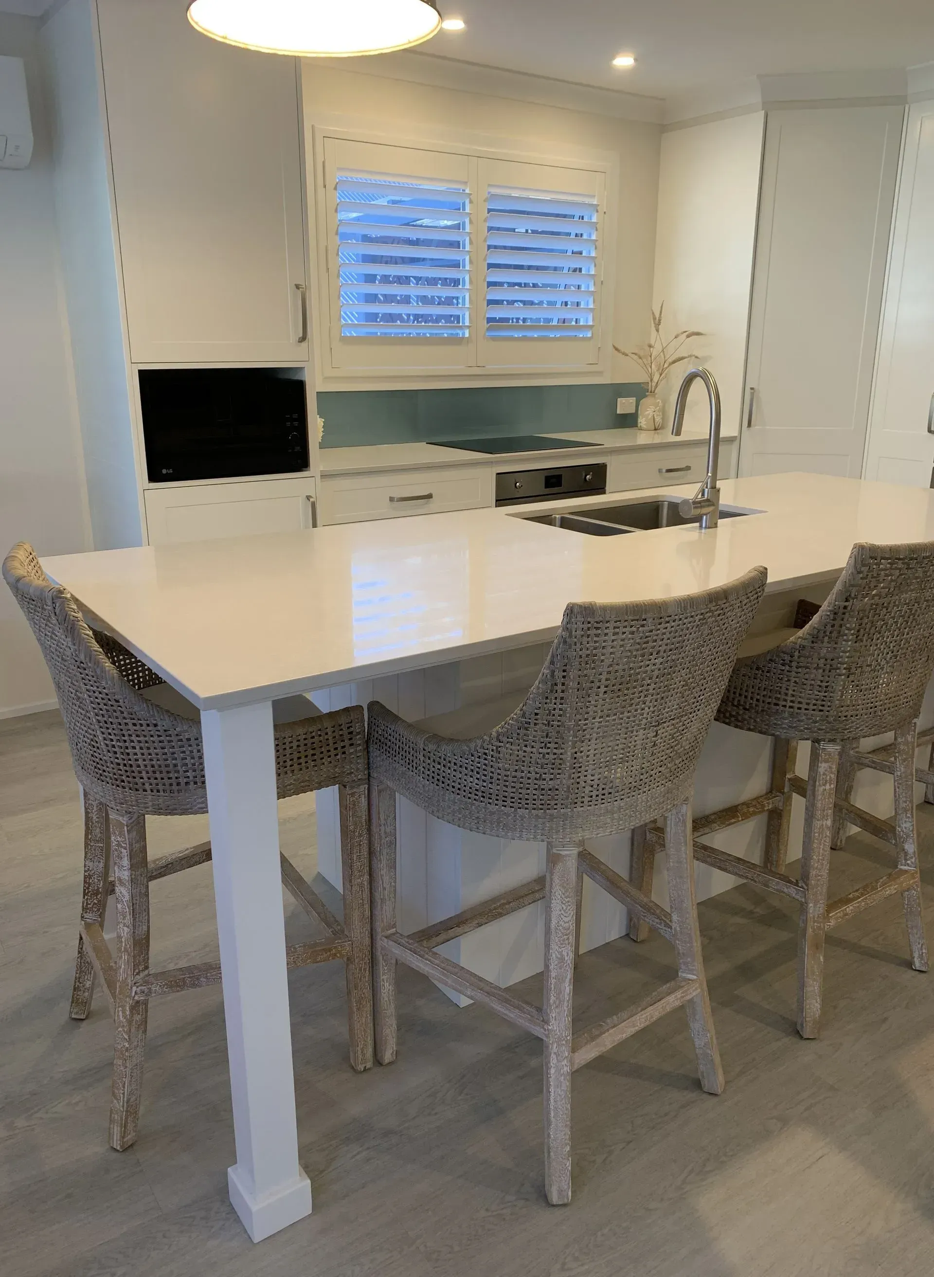 Kitchen Island With Woven Bar Stools. White Cabinets, Countertops, Shutters — The Kitchen Centre In Tuggerah, NSW