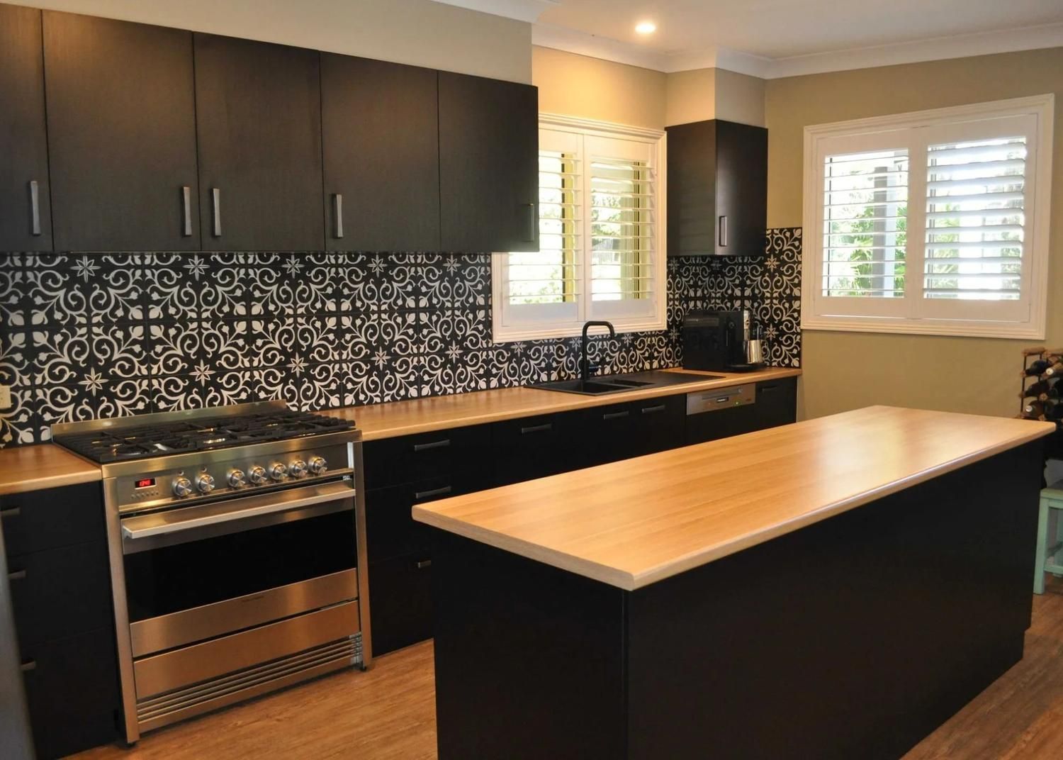 A Kitchen With Black Cabinets and Stainless Steel Appliances — The Kitchen Centre In Tuggerah, NSW