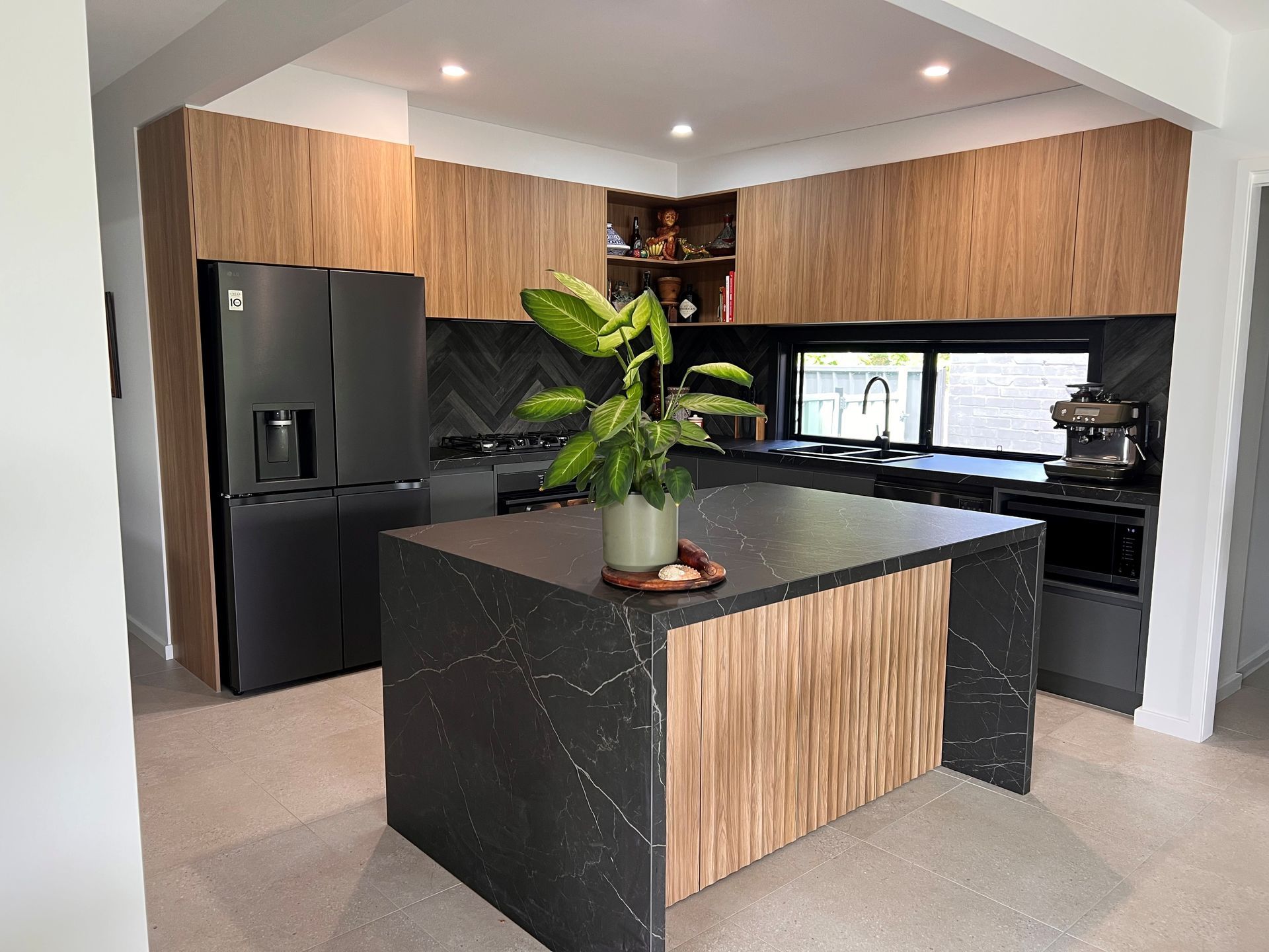 A Kitchen With a Large Island and a Plant on the Counter — The Kitchen Centre In Tuggerah, NSW