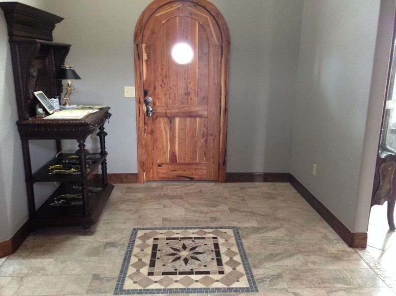 A hallway with a wooden door and a mosaic floor