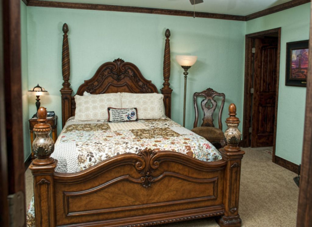 A bedroom with a king size bed and a chair.