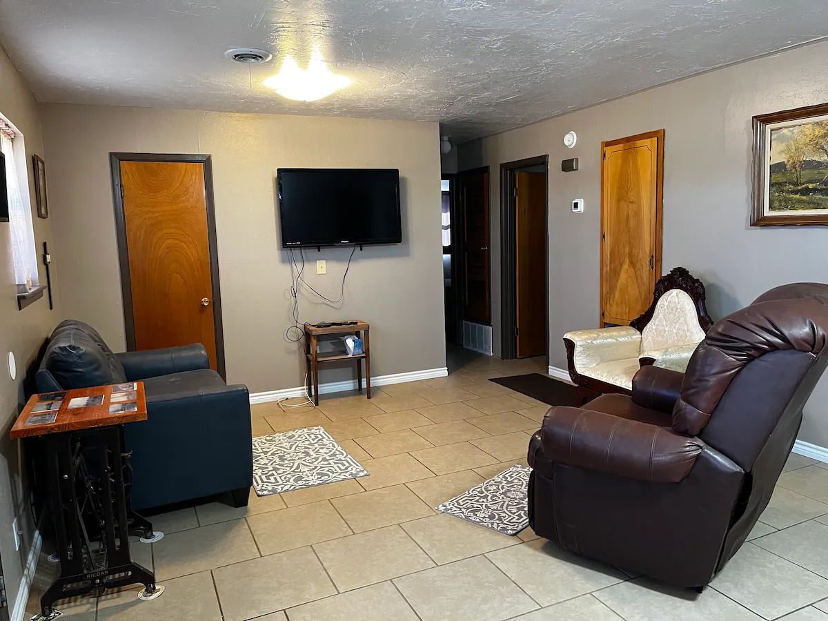 A living room with a couch , chair , and television.