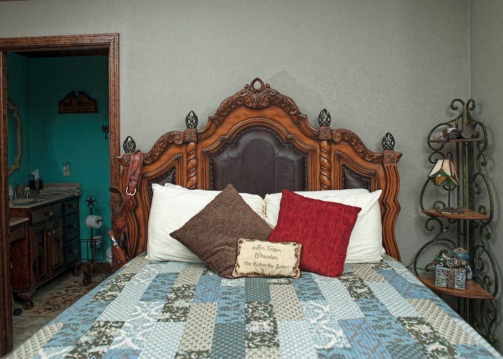 A bed with a wooden headboard and pillows in a bedroom.